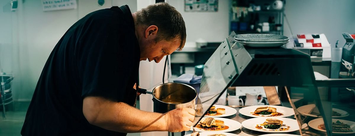 Chef dressant ses assiettes en cuisine professionnelle